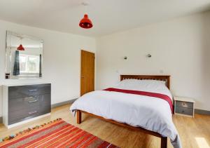um quarto branco com uma cama e uma janela em Hawthorn Cottage 