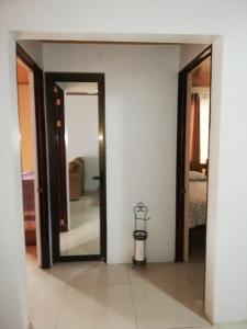 a hallway with a mirror and a room with a bed at Central 3 Bedroom Quepos Home in Quepos