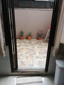 an open door with potted plants on a tile floor at Central 3 Bedroom Quepos Home in Quepos