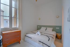 een slaapkamer met een bed, een dressoir en een raam bij NOCNOC - Le Ceramica - Le calme en ville, T3 très fonctionnel in Montpellier