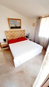 1 dormitorio con 1 cama blanca grande con almohadas rojas en Dom 200 m2 z widokiem na morze, en Salamina