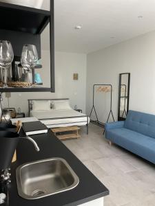 una cocina con fregadero y un sofá en una habitación en PTM DownTown Hostel&Suites, en Portimão