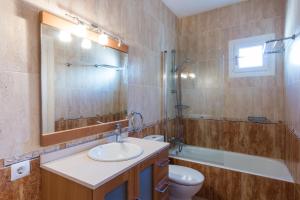 Un baño con lavabo, inodoro y espejo. en Villa TRES JOANS, en Cala Galdana 4 fotos más