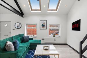een woonkamer met een groene bank en een tafel bij Elegant Yorkshire Abode - Great Location - Sleeps 19 in Castleford