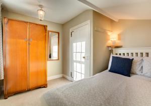 a bedroom with a bed and a wooden cabinet at Holly Cottage in Cromer