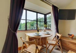 a dining room with a table and chairs and a window at Holly Cottage in Banningham