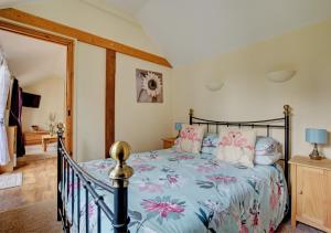 a bedroom with a bed with a floral bedspread at Holly Cottage in Banningham