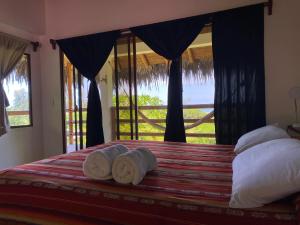 a bedroom with a bed with a view of the ocean at Hosteria Guachapeli in Las Tunas