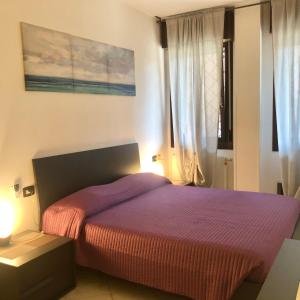 ein Schlafzimmer mit einem Bett mit einer lila Decke in der Unterkunft Residenza Borghetto sul Reno in Castel Maggiore