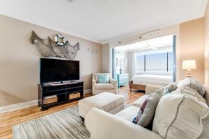 a living room with a couch and a flat screen tv at Sunset Harbor Palms 1-311 in Navarre