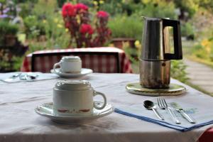 un tavolo con una tazza e una caffettiera sopra di Agriturismo alle Torricelle a Verona