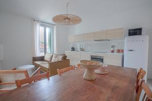 NOCNOC - L'Amarelo - Charmant T4 avec terrasse au calme في مونبلييه: مطبخ وغرفة طعام مع طاولة خشبية