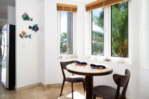 een tafel en stoelen in een kamer met ramen bij The Cottonwood House - Beach Villa in Providenciales