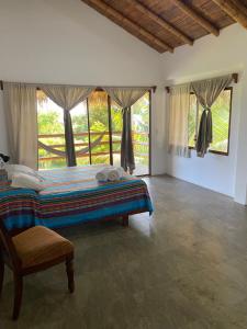 a bedroom with a bed and a large window at Hosteria Guachapeli in Las Tunas