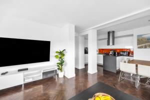 a living room with a flat screen tv on a wall at 23rd Floor 3BR Apt with Views of Warsaw in Warsaw
