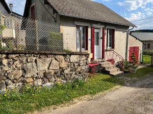 dom z kamienną ścianą i płotem w obiekcie Maison au coeur du Morvan w mieście Arleuf