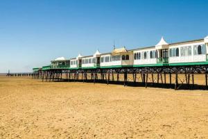 a long pier on the beach with buildings at The Old Station House by Holiday Heim in Lytham St Annes