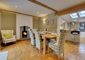 Keepers Cottage في Panxworth: غرفة طعام مع طاولة وكراسي ومدفأة