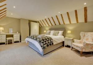 a bedroom with a bed and a desk and a chair at Keepers Cottage in Panxworth