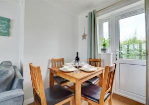 jadalnia ze stołem i krzesłami oraz oknem w obiekcie Lane End Cottage w mieście Snettisham