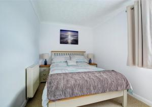 - une chambre avec un lit et une photo sur le mur dans l'établissement Lane End Cottage, à Snettisham