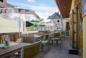 Kirchenwirt في Kaumberg: مطعم بطاولات وكراسي ومظلة