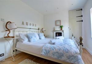 a white bedroom with a bed and a fireplace at Lavender Cottage in North Creake