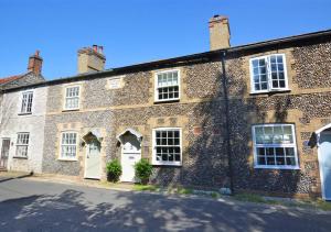 a large brick building with white doors and windows at Lavender Cottage in North Creake