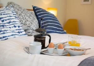 a breakfast tray with eggs and a coffee maker on a bed at Larkrise in West Runton