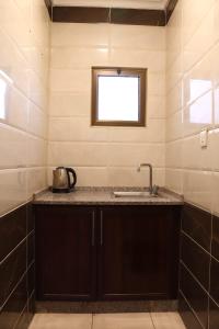 eine Küche mit einem Waschbecken und einem Fenster in der Unterkunft Future 2 Hotel Apartments in Aqaba