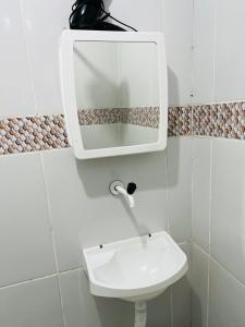 baño con lavabo y espejo en la pared en La casita Verde, en Beberibe