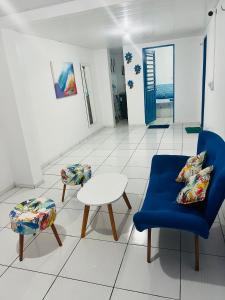 sala de estar con silla azul y mesa en La casita Verde, en Beberibe
