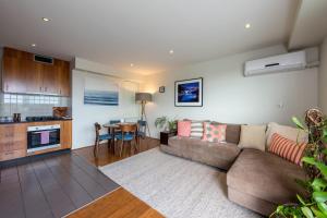 sala de estar con sofá y mesa en Beautiful 1-Bed in St Kilda w Parking & Terrace, en Melbourne