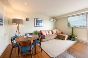 a living room with a couch and a table at Beautiful 1-Bed in St Kilda w Parking & Terrace in Melbourne