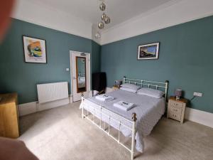 1 dormitorio con 1 cama y paredes azules en The Portland Hotel en Folkestone