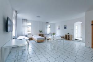 a white living room with a table and a couch at T&K Apartments - 1-3 Zimmer Apartments - Essen in Essen