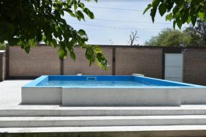 een zwembad in een tuin met enkele trappen bij Casa con pileta in Santiago del Estero