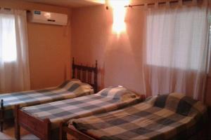 2 aparte bedden in een kamer met een raam bij Casa con pileta in Santiago del Estero