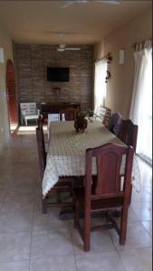 een eetkamer met een tafel en stoelen en een televisie bij Casa con pileta in Santiago del Estero