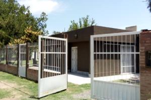 een hek met witte poorten voor een gebouw bij Casa con pileta in Santiago del Estero