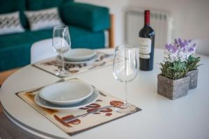 een tafel met borden en glazen en een fles wijn bij Gente del Sur - 25 de mayo in Ushuaia