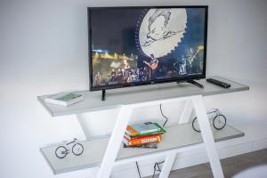 een flatscreen-tv op een witte stand met een televisie erop bij Gente del Sur - 25 de mayo in Ushuaia