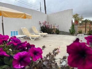 two chairs and a table and some pink flowers at Casa rosa in San Miguel de Abona