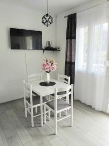 Biały stół i krzesła z wazonem kwiatów na nim w obiekcie Apartment Marina 2 w Kotorze