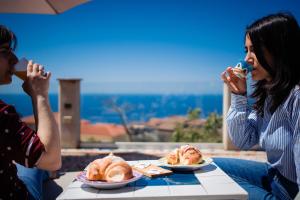 two people sitting at a table with plates of food at Villa Santa Sofia in Ascea