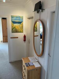 Zimmer mit einem Spiegel und einer Kommode mit einem Tisch in der Unterkunft Seestern in Hörnum