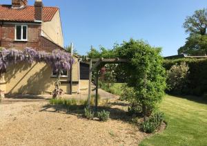 a garden with a wreath of purple flowers at Lilac Cottage in Hindolveston
