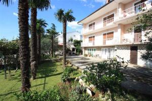 a large building with palm trees in front of it at One-Bedroom Apartment Crikvenica 14 in Dramalj
