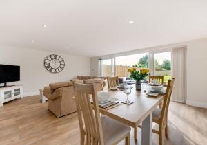 a dining room and living room with a table and chairs at Lillie Cottage in Brisley