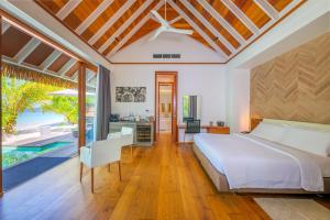 a bedroom with a bed and a kitchen and a pool at Kandolhu Maldives in Himandhoo 